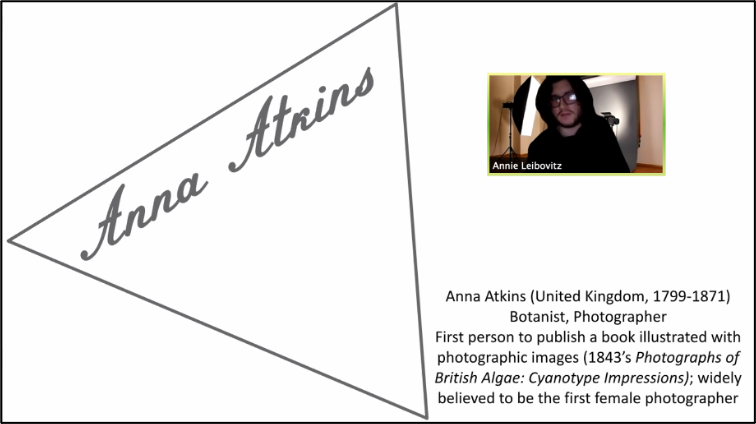 Fig. 8. Jack Leach, Anna Atkins Heritage Floor Virtual Presentation. This image depicts a white square, with a sideways triangle on the left in black, in which the name “Anna Atkins” is written. On the right is a video screen capture of a student in a black hoodie and glasses, with the name “Annie Lebovitz” written beneath. Underneath the screen capture is the following text: “Anna Atkins (United Kingdom, 1799-1871) / Botanist, Photographer / First person to publish a book illustrated with photographic images (1843’s Photographs of British Algae: Cyanotype Impressions); widely believed to be the first female photographer.”