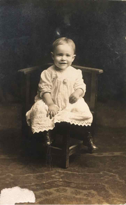 photograph of a toddler sitting on a chair